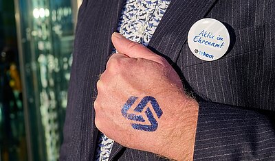 Hand mit Tattoo vom tekom-Logo auf einer Hand